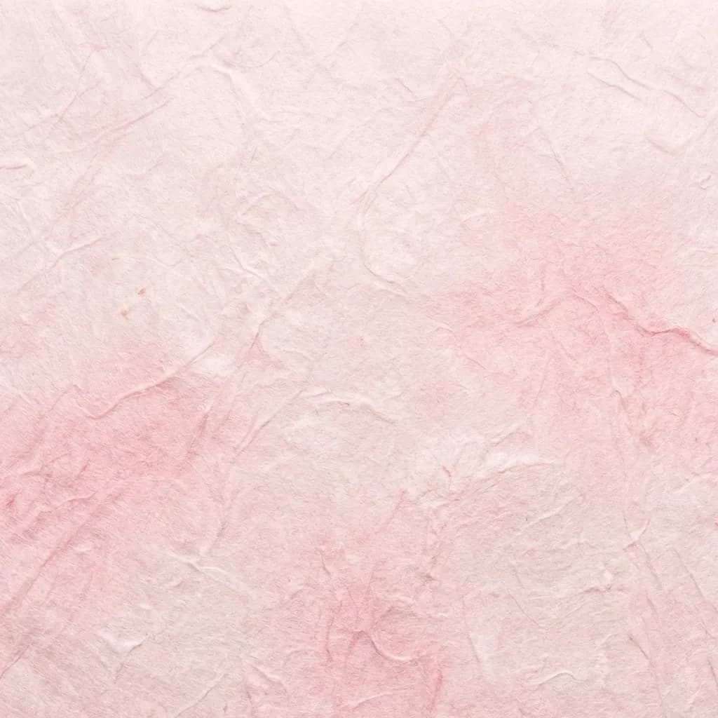 淡いパステルピンクの濃淡が美しい、しわや繊維感のある繊細な紙のテクスチャ背景です。表面には、手漉きの和紙を思わせるような、優しく有機的なしわや折り目のパターンが見られます。この柔らかな質感と落ち着いた色合いが、静かで優雅な雰囲気を作り出しています。