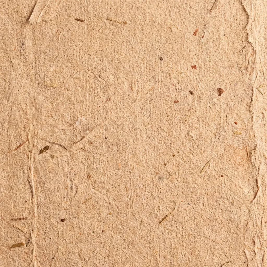 薄茶色の手漉き紙の質感が際立つクローズアップ画像です。表面には自然な繊維や小さな濃い斑点が埋め込まれており、素朴でオーガニックな風合いと、ややざらついた端が特徴です。