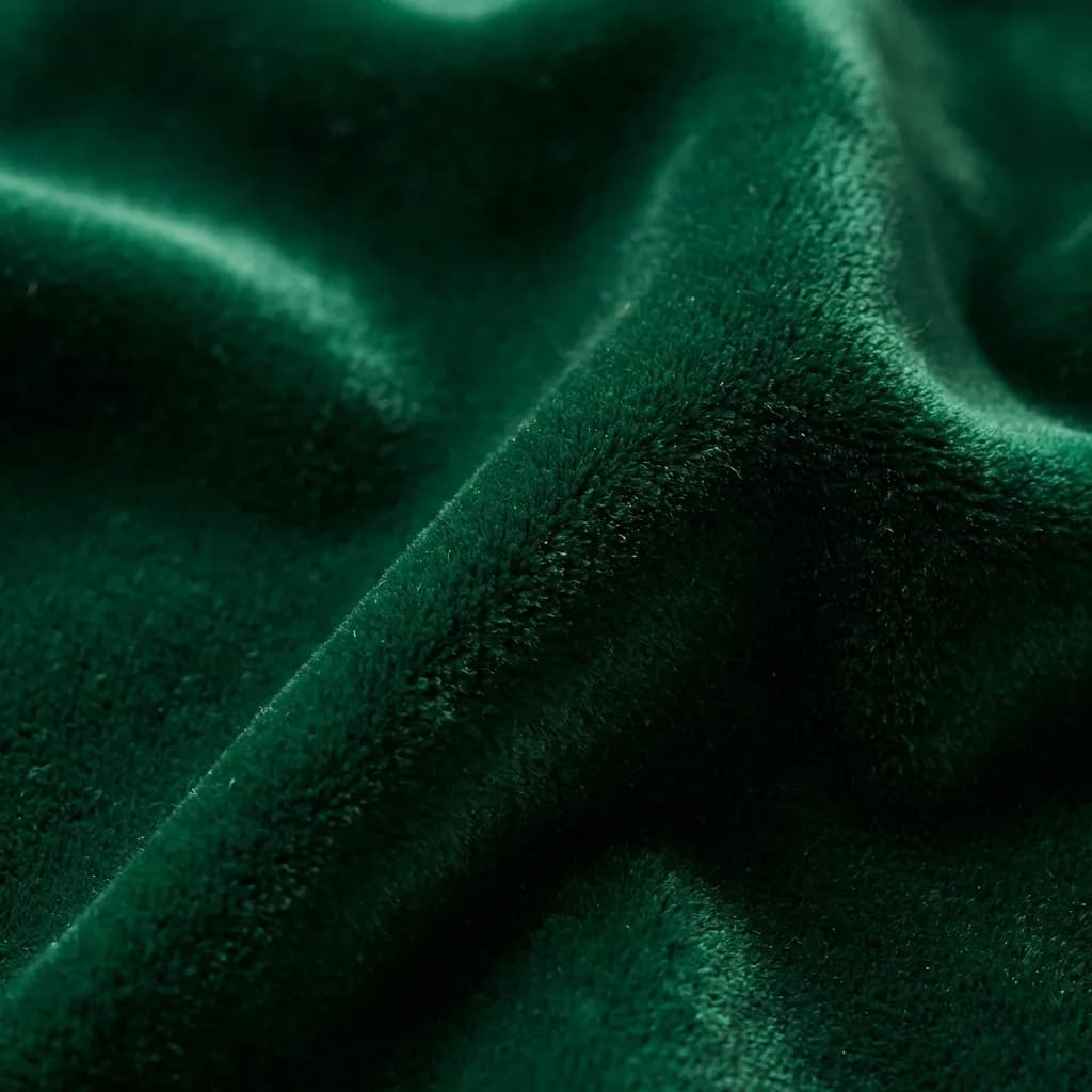 深みのあるエメラルドグリーンの、柔らかく毛足の長い高級感あふれる生地のクローズアップ写真です。優雅なドレープと微妙な光の加減が、生地の持つ豊かな質感と心地よい柔らかさを際立たせ、見る人に触れてみたくなるような感覚を与えます。