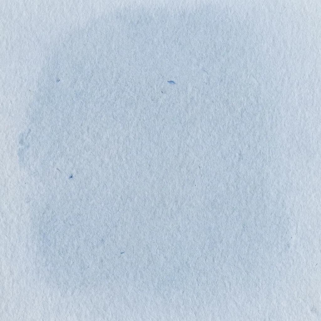 この画像は、淡い水色のテクスチャーのある紙の全面を捉えており、手漉き紙や水彩紙のような繊細で落ち着いた背景を作り出しています。表面には、かすかな水痕や小さな濃い色の繊維が散りばめられた、わずかに不均一な青い色合いの有機的な質感が見られます。全体として穏やかでミニマリストな雰囲気を持ち、静かな背景や芸術的な表現に最適です。