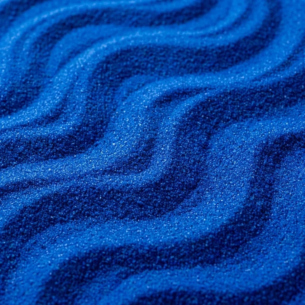 鮮やかなロイヤルブルーの砂が、優雅に波打つような模様に細かく整えられています。粒子の粗い表面に光と影が織りなす繊細なコントラストが、ミニチュアの枯山水や穏やかな海底を思わせる、静かでリズミカルな曲線美を際立たせています。